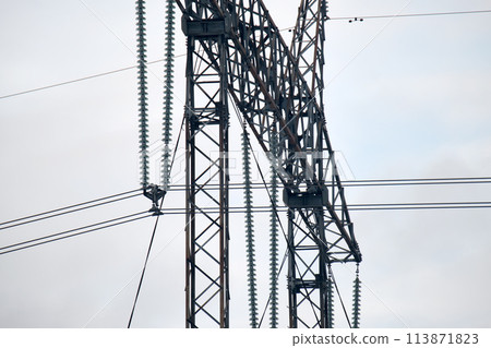 High voltage insulation string on steel pillar with electric power lines for safe delivering of electrical energy through cable wires on long distance High voltage insulation string on steel pillar with electric power lines for safe delivering of electrical energy through cable wires on long distance 113871823