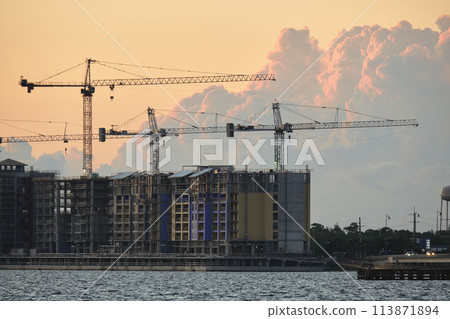 Tower lifting cranes at high residential apartment buildings construction site. Real estate development 113871894