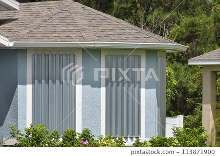 Steel storm shutters for hurricane protection of house windows. Protective measures before natural disaster in Florida Steel storm shutters for hurricane protection of house windows. Protective measures before natural disaster in Florida 113871900