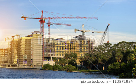 Tower cranes and frame structure of high residential apartment buildings at construction site. Real estate development Tower cranes and frame structure of high residential apartment buildings at construction site. Real estate development 113871984
