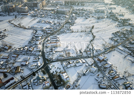 Aerial view of private homes with snow covered roofs in rural suburbs town area in cold winter 113872850