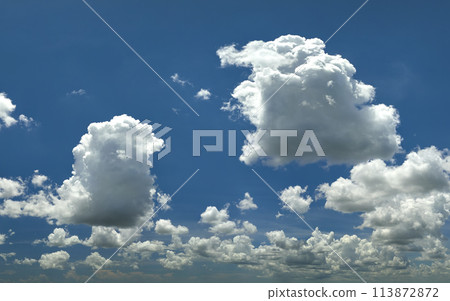 White puffy cumulus clouds on summer blue sky 113872872