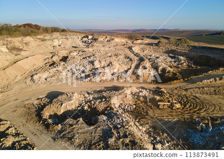 Aerial view of open pit mining site of limestone materials for construction industry with excavators and dump trucks 113873491