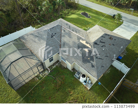 Hurricane Ian destroyed house roof in Florida residential area. Natural disaster and its consequences 113873499
