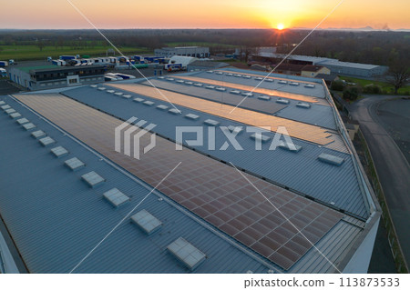 Blue photovoltaic solar panels mounted on building roof for producing clean ecological electricity at sunset. Production of renewable energy concept 113873533