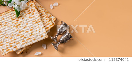 Happy Passover. Traditional Jewish holiday. Silver wine cups, spring flowers and matzo bread Happy Passover. Traditional Jewish holiday. Silver wine cups, spring flowers and matzo bread 113874041