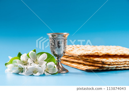 Happy passover. Metal goblet and traditional matzah on blue background. Happy passover. Metal goblet and traditional matzah on blue background. 113874043