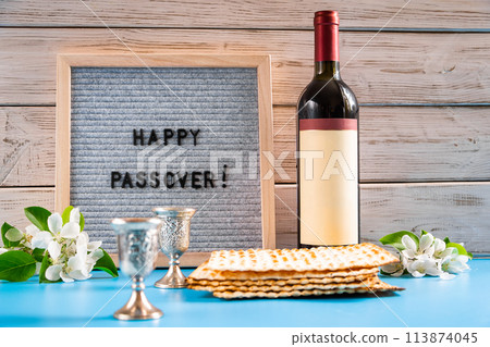 Celebrating spring holiday Passover. Bottle of wine and traditional Jewish matzo bread Celebrating spring holiday Passover. Bottle of wine and traditional Jewish matzo bread 113874045