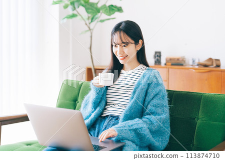 一個女人在沙發上使用電腦 113874710