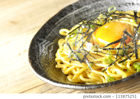 Hot oil soba noodles topped with egg yolk, shredded seaweed, and spring onions 113875251