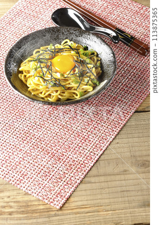 Hot oil soba noodles topped with egg yolk, shredded seaweed, and spring onions 113875365