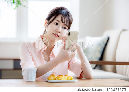 Woman looking at a smartphone in the morning 113875375
