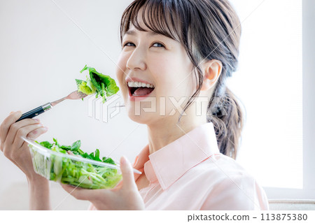 Woman eating salad 113875380