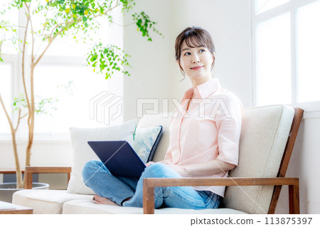 A woman touching a computer in the living room A woman touching a computer in the living room 113875397