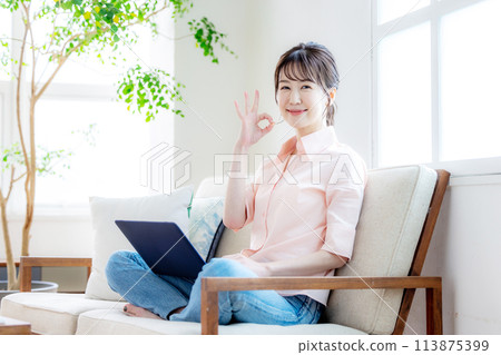 A woman touching a computer in the living room A woman touching a computer in the living room 113875399