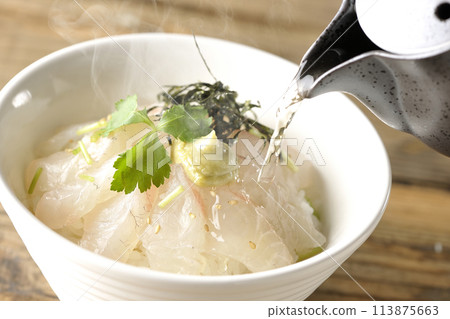 Pour hot broth over sea bream chazuke topped with mitsuba, shredded seaweed, and wasabi. Pour hot broth over sea bream chazuke topped with mitsuba, shredded seaweed, and wasabi. 113875663