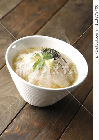 Hot sea bream chazuke with hot dashi broth and topped with mitsuba, shredded seaweed, and wasabi 113875700