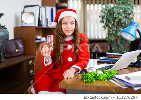 Nice lady with glass of champagne celebrating Christmas in office Nice lady with glass of champagne celebrating Christmas in office 113876287