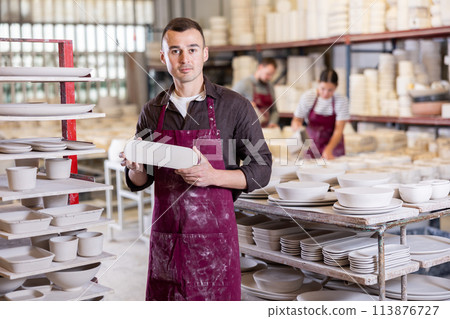 Young man posing with ceramic blanks 113876727