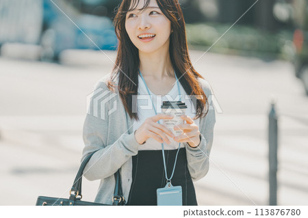 A woman drinking coffee near the office on a sunny day A woman drinking coffee near the office on a sunny day 113876780