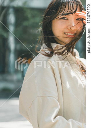 A woman refreshing herself while walking through a fashionable town A woman refreshing herself while walking through a fashionable town 113876790