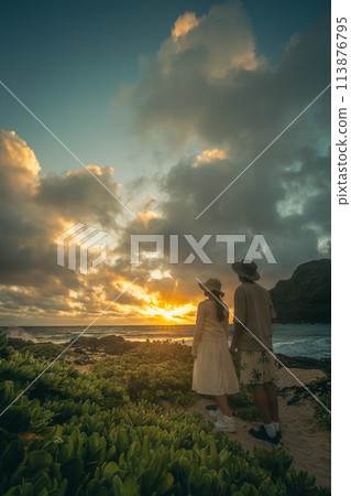Young man and woman watching the sunrise at Makapuu, Hawaii Young man and woman watching the sunrise at Makapuu, Hawaii 113876795
