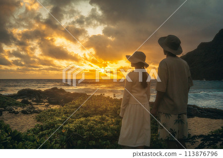 Young man and woman watching the sunrise at Makapuu, Hawaii Young man and woman watching the sunrise at Makapuu, Hawaii 113876796