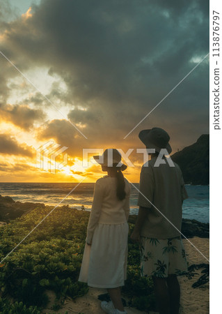 Young man and woman watching the sunrise at Makapuu, Hawaii Young man and woman watching the sunrise at Makapuu, Hawaii 113876797