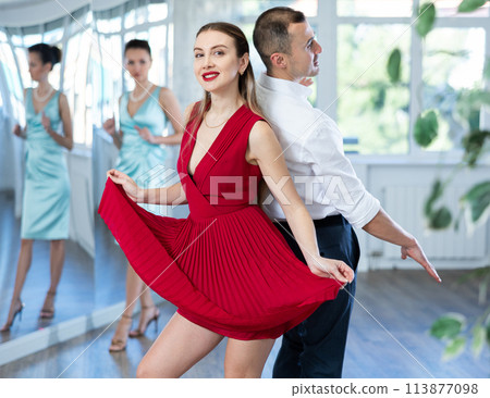 Couple in stage costumes learns boogie woogie dancing during individual lesson Couple in stage costumes learns boogie woogie dancing during individual lesson 113877098