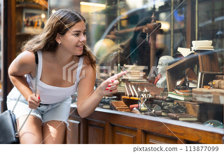 Interested young woman viewing retro-style stationery in souvenir store Interested young woman viewing retro-style stationery in souvenir store 113877099