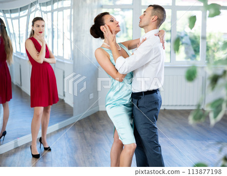 Coach, paired with man student, shows master class and explains technique of tango dance Coach, paired with man student, shows master class and explains technique of tango dance 113877198