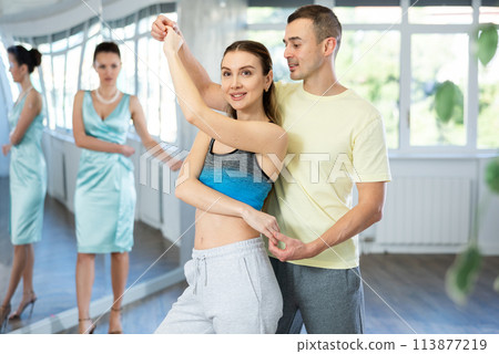 Couple in comfortable sports clothes waltz dancing during individual lesson 113877219