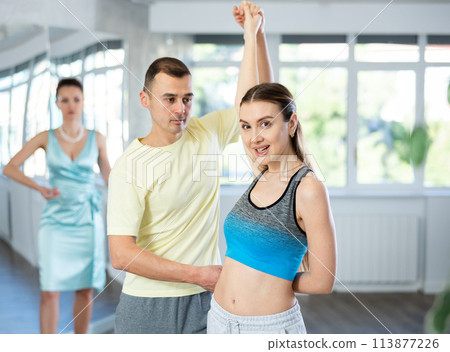 Smiling woman and man dancing bachata in choreography studio Smiling woman and man dancing bachata in choreography studio 113877226