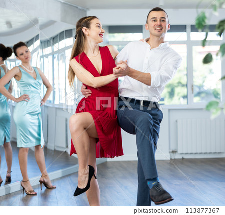 Couple in stage costumes learns boogie woogie dancing during individual lesson 113877367