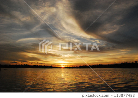 Tropical amazing dramatic golden sky on sunset over scenic river lake seascape ocean. Silhouette tranquil season wilderness serene landscape. Tranquil lake countryside sunrise seaside reflection Tropical amazing dramatic golden sky on sunset over scenic river lake seascape ocean. Silhouette tranquil season wilderness serene landscape. Tranquil lake countryside sunrise seaside reflection 113877488