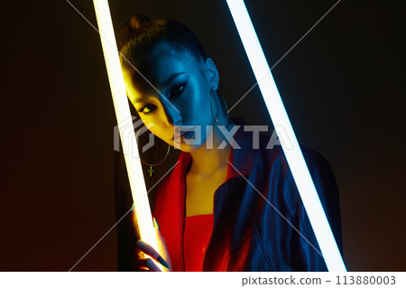 beautiful young woman in color lights. Brunette girl with long Nails 113880003