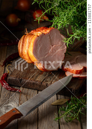 Smoked pork ham on a wooden table. Smoked pork ham on a wooden table. 113881757