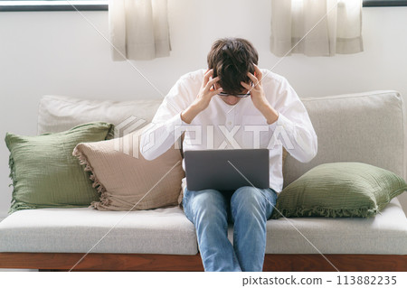 在沙發上使用筆記本電腦的男人 113882235