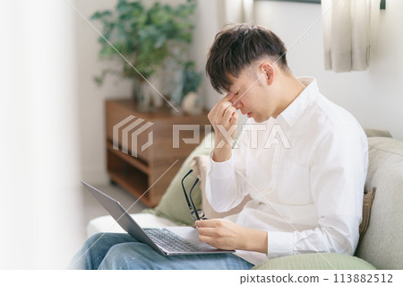 A man holding his eyes A man holding his eyes 113882512