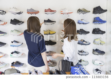 Back view of young woman shopping at shoe shop Back view of young woman shopping at shoe shop 113883156