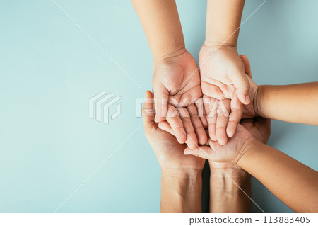 Family top view hands stacked on isolated background. Parents and kid hold empty space expressing support and love for Family and Parents Day. Family top view hands stacked on isolated background. Parents and kid hold empty space expressing support and love for Family and Parents Day. 113883405