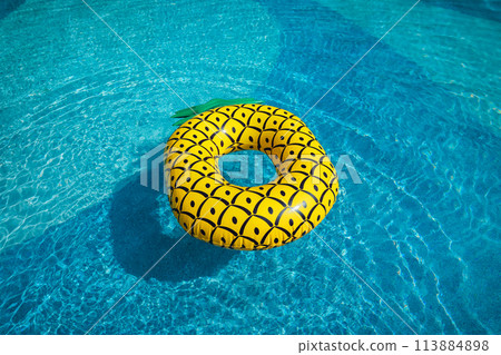 Yellow rubber ring floating in a blue pond on a summer day Yellow rubber ring floating in a blue pond on a summer day 113884898