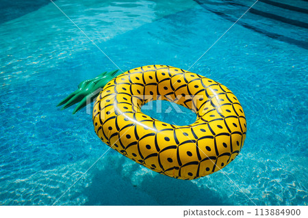 Yellow rubber ring floating in a blue pond on a summer day 113884900