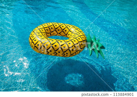 Yellow rubber ring floating in a blue pond on a summer day 113884901