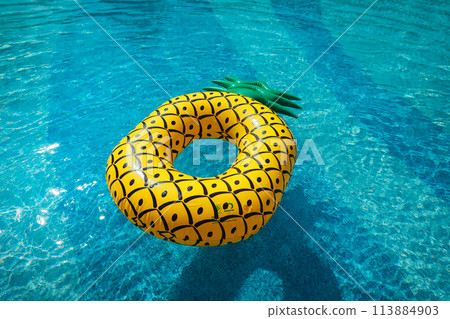 Yellow rubber ring floating in a blue pond on a summer day 113884903