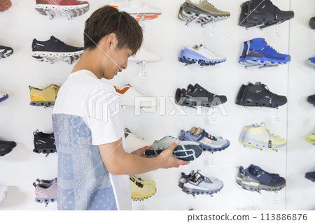 Young man shopping at a sports apparel store 113886876