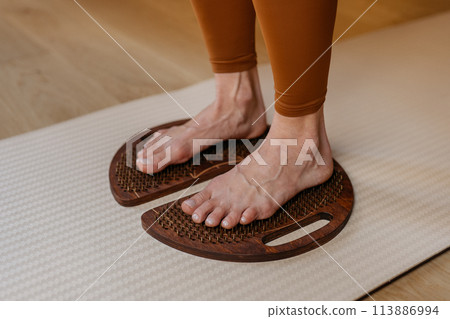 Acupressure in action with feet firmly placed on wooden sadhu boards 113886994