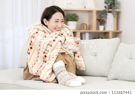 Woman relaxing in the living room, warming up, poor circulation 113887441