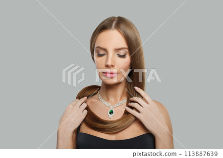 Attractive glamorous woman with brown hair, makeup and gold jewelry closeup fashion beauty portrait 113887639