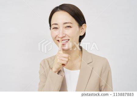 Middle-aged businesswoman making a secret gesture on white background Middle-aged businesswoman making a secret gesture on white background 113887883